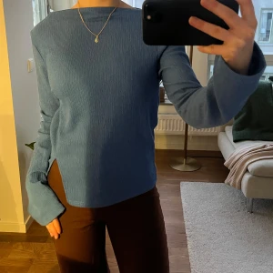 Blå långärmad topp  - Blå långärmad topp från Gina Tricot. Toppen har en båtringning samt en slits på sidan fram