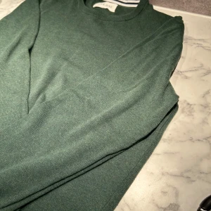 Grön tröja från Pier One - Snygg grön tröja från Pier one i en klassisk design. Tröjan har långa ärmar och är perfekt inför våran. Tröjan är grön som på första bilden, blev fel med ljuset!! Hör av er vid intresse🤩