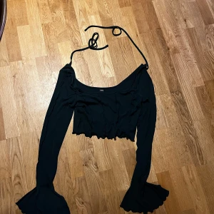 Mörkgrön  topp - Snygg mörkgrön topp från Shein med långa ärmar och volangdetaljer vid ärmslut och nederkant. Toppen har en croppad passform och knytband bak i ryggen för en justerbar look.