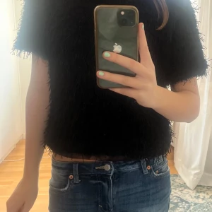 Svart fluffig topp - Säljer en svart fluffig topp med korta ärmar. Nästan aldrig använd 