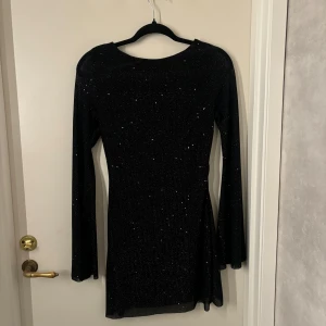 Svart glittrig klänning - Svart glittrig klänning med öppen rygg, endast använd en gång, skriv för mer bilder🩷