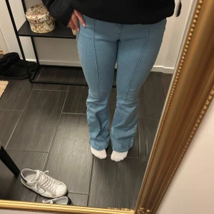 Ljusblå bootcut jeans - Snygga ljusblå bootcut jeans med hög midja. De har en klassisk design med sömmar längs benen som ger en stilren look. Perfekta för en avslappnad stil.