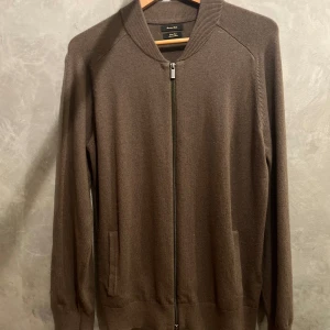Stickad cardigan | Massimo Dutti - Skogs grön/ brun stickad cardigan från Massiomo Dutti. Det har två fickor på framsidan. Materialet är ylle. Använd nån gång bara! Hör av dig vid frågor! 