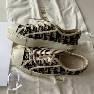 Walk’n dior skor 35,5 - Säljer nu mina super fina Walk’n dior sneakers i superbra skick!❤️ De är perfekta som skor till våren och sommaren🤗🌸 De är i storlek 35,5, innersulans längd är 23cm, passar mig som brukar ha 36,5, men lite lite små💫 monogrammet är blått och krämvit och sulan är vit❤️  Alla tillbehör på bilderna tillkommer, inklusive original kvitto som ligger i kuvertet. Kan skicka bild på kvittot om det önskas. Orderbekräftelse från Vestiaire Collective finns även