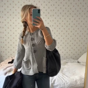 Grå kofta med knappar - Säljer en stilren grå kofta med stora knappar och trekvartsärmar. Koftan har en ribbad design upptill och praktiska fickor framtill💕🫶🏼den är i storlek m men passar som en s 