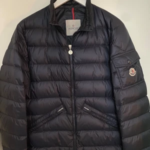 Moncler agay jacka  - Säljer en perfekt jacka till våren: Moncler agay jacka (Mörkblå, Storlek 4). Skick: 8/10, sparsamt använd. Medföljer: tags, den gråa triangeln samt extra knappar. Kan mötas upp i Göteborg eller i närheten av Göteborg. Pris kan diskuteras vid snabb affär. Passar M/L.