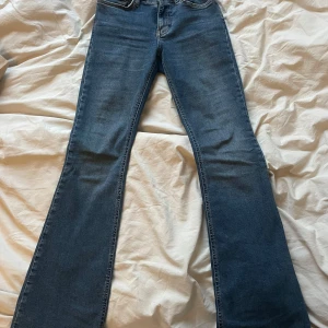 Blå bootcut jeans - Snygga blå bootcut jeans ifrån Gina tricot storlek 34. Perfekta för en avslappnad stil. De har en bekväm passform och är tillverkade i ett slitstarkt material. Har lite tecken på användning längst ner på byxan annars i jättebra skick!!🌟