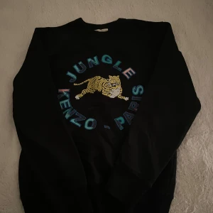 Svart sweatshirt från Kenzo x H&M - Super snygg tröja från kenzo, knappt använd så skicket är som ny!! Xs men passar perfekt för mig som valigtvis har s-m!!