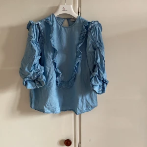 Säljer en ljusblå blus från Zara - En jättefin puffig blus med volanger. Jätteskön och är i storlek S