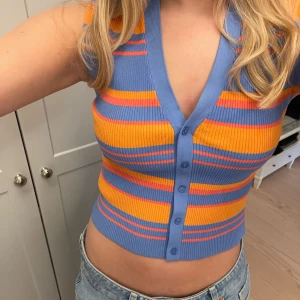 Randig topp från Zara - Säljer en färgglad randig västtopp från Zara i blått och orange. Knappt använd! 