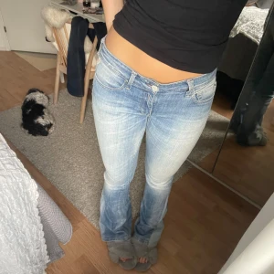 Blå jeans från Replay - Säljer ett par snygga ljusblå jeans från Replay. De är bootcut och lågmidjade, super långa också! Passar mig som är 173 och vanligtvis har 36/38 i jeans. Midja 38cm, innerbenslängd 85cm