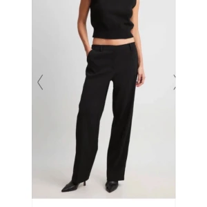 Lågmidjade kostymbyxor - Snygga svarta kostymbyxor från NA-KD i en rak modell med låg midja. Nya med prislapp. Säljer för att de är för långa för mig. Nypris: 599kr