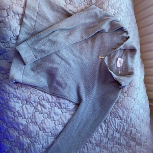 Grå tröja från Lindbergh - Säljer en stilren grå tröja från Lindbergh i ekologisk bomull. Tröjan har en dragkedja vid halsen och långa ärmar. Perfekt för en avslappnad look. 