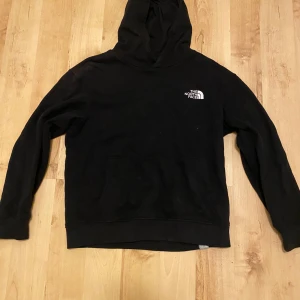 Svart hoodie från The North Face - Säljer en klassisk svart hoodie från The North Face. Mycket fint skick. Använd endast några gånger. Det är storlek L men i barn storlek så ungefär 146-151cm