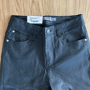 Svarta byxor från MINGEL - Svarta skinnbyxor i skinnimitation från Mingel. Nypris 599kr. Helt nya. Smal modell. Innerbenslängd ca 76/77 cm. Rökfritt hem.