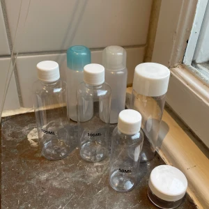 Tomma plastflaskor i olika storlekar - Säljer ett set med tomma plastflaskor i storlekarna 50 ml och 100 ml. Perfekta för resor eller förvaring av vätskor. Flaskorna har vita skruvlock och är genomskinliga, vilket gör det enkelt att se innehållet. Praktiska och återanvändbara.