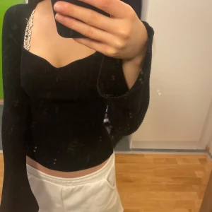 Svart ribbad topp - Snygg svart ribbad topp med långa ärmar och fyrkantig halsringning. Storlek S/M passar även mig som vanligtvis har XS men är stretchig. 