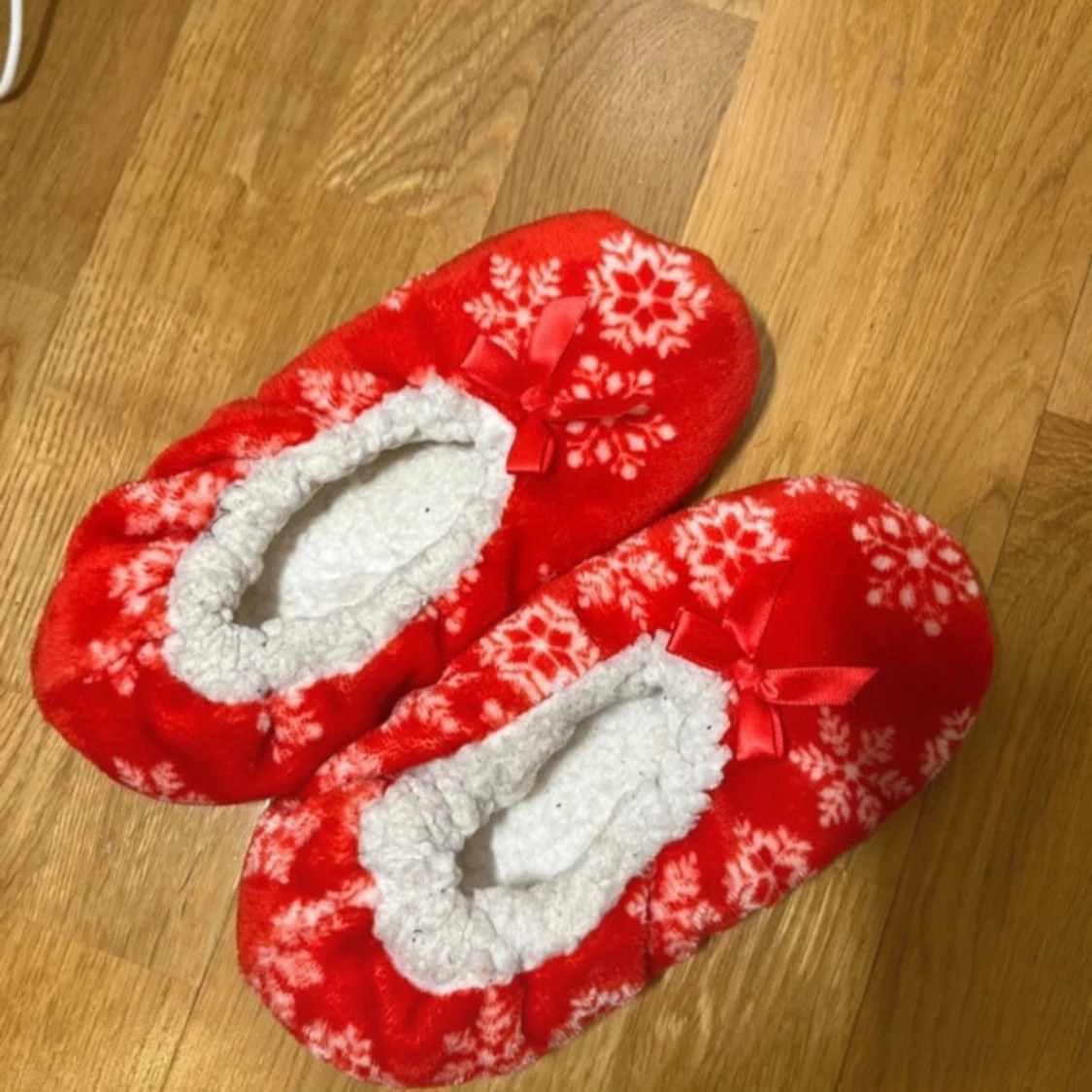 Röda tofflor med snöflingemönster