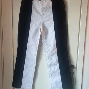 Svartvita byxor från NA-KD - Snygga svartvita byxor från NA-KD med unikt mönster. Byxorna har en rak passform och är perfekta för att sticka ut. Tillverkade i ett bekvämt material som passar bra till olika tillfällen.