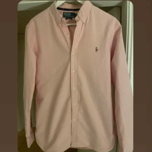 Ralph Lauren skjorta - Snygg väldigt ljus rosa skjorta från Ralph Lauren             Storlek M                                                                                 Nyskick                                                                                  Nypris/butikspris: 1600 kr på Care of Carl