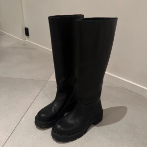 Svarta stövlar från Vagabond - Snygga svarta stövlar från Vagabond i skinn. De har en hög skaft och en robust sula som ger bra grepp. Perfekta för både höst och vinter. Storlek 38 och använda endast två gånger så otroligt bra skick. Nypris och köpta för 2000.