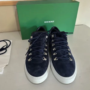 Mörkblå sneakers från Diemme - Snygga mörkblå sneakers från Diemme i mocka med vita sulor. Skorna har silverfärgade snörhål och en stilren design som passar perfekt för en avslappnad look.