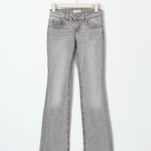 Grå y2k bootcut jeans från Ginatricot, storlek 32 - Snygga grå y2k bootcut jeans från Ginatricot. De har en klassisk femficksdesign med knappar på bakfickorna och en bekväm passform. De passade fint på mig men tyvärr var jag för kort för byxorna, köpte dom i storlek 32. Var på väg och returnera men kunde tyvärr inte returneras pga av etiketten där de stod storlek inte va kvar. Tveka inte för att höra av om fler bilder eller information💗