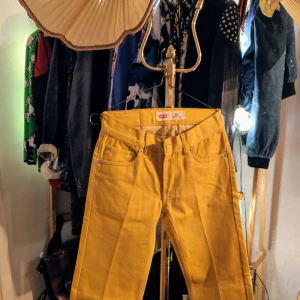 Gula jeans från Levi's NYA! - Snygga gula jeans från Levi's med klassisk femficksdesign. Perfekta för att liva upp garderoben med en färgklick. Passar både till vardags och mer avslappnade tillfällen. Helt oanvända! Storlek: 10 Regular, W25, L25.