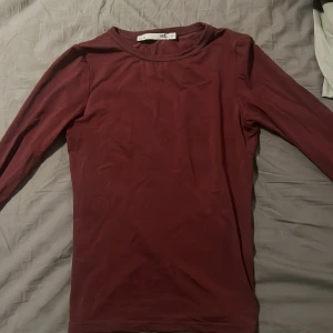 Vinröd långärmad topp från 157 - Säljer en stilren vinröd långärmad topp från 157. Perfekt för lager-på-lager eller som den är. Enkel design med rund halsringning.