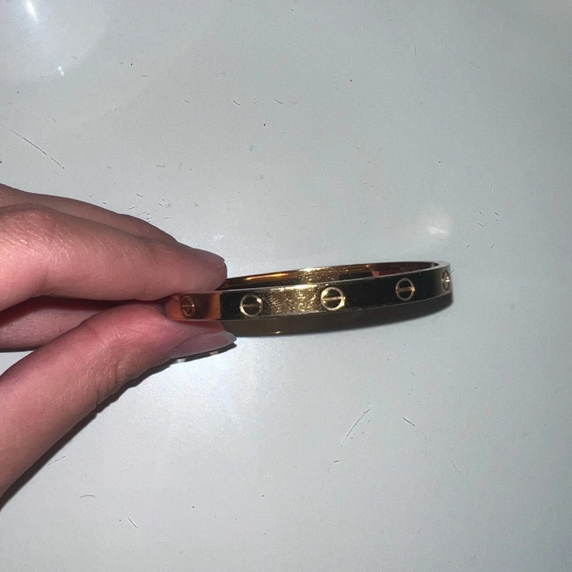 Guldarmband med skruvdetaljer