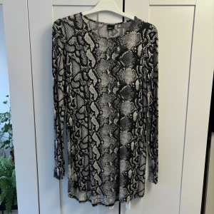 Ormmönstrad tröja från Gina Tricot - Säljer en cool långärmad tröja från Gina Tricot i storlek M. Lång, mjuk och super skönt material och jättefint skick. Har endast använt den ett fåtal gånger och säljer eftersom jag inte använder den. 93% viskos, 7% elastan. 💕