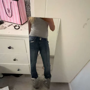 Blå bootcut jeans från Bershka - Säljer ett par snygga blå bootcut jeans från Bershka. De har en klassisk femficksdesign och en bekväm passform. Perfekta för en avslappnad stil. Tillverkade i denim med en lätt tvättad look. Använda flertal gånger därför lågt pris.