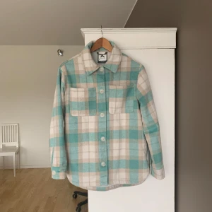 Rutig overshirt från McKinley - Säljer en snygg rutig overshirt från McKinley i beige och turkos. Skjortan har långa ärmar och knappar framtill. Endast andvänd några gånger. Perfekt nu till våren då det börjar bli lite varmare. Priset går att diskutera vid en snabb affär. Kontakta gärna mig om du vill ha fler bilder eller om du har frågor.