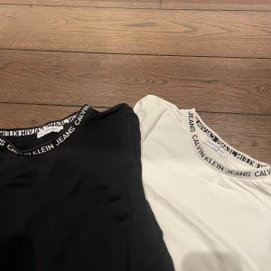 Svart och vit t-shirt från Calvin Klein - Två stilrena t-shirts från Calvin Klein i svart och vitt. Båda har korta ärmar och en rund halsringning med Calvin Klein Jeans-logga. Skriv för mer bilder och frågor. En tröja för 200 och båda för 300