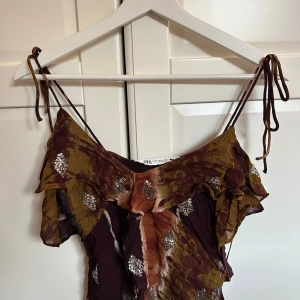 Mönstrad topp från Zara - Säljer en mönstrad topp från Zara med tunna axelband och volangdetaljer. Toppen är i ett jötte bra skick💓