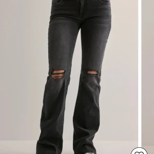 Lågmidjade jeans Nelly❤️ - Snygga svarta bootcut jeans med slitningar på knäna. Lågmidjade och från Nelly!❤️ använd ett fåtal gånger❤️