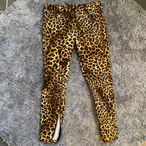 Leopardmönstrade byxor från Zara - Snygga leopardmönstrade byxor från Zara med en tight passform. Byxorna har en slits vid ankeln med dragkedja. Säljs då de inte kommer till användning längre. Bilder i lite olika ljus för att få en uppfattning om färgen.