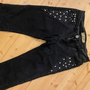 Svarta jeans med pärldetaljer - Snygga svarta capri jeans med pärldetaljer. Köpta second hand, står XL men passar mig med 38