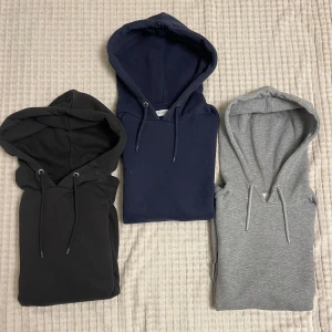 Tre hoodies i olika färger - Säljer dessa tre snygga hoodies i svart, blått och grått. Perfekta för chill dagar, med justerbara snören i huvan. Passar bra till både vardag och fritid.