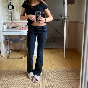 Svarta bootcut jeans - Snygga svarta bootcut jeans med låg midja. Perfekta för en avslappnad stil. De har en klassisk design med knappar och dragkedja framtill. Med fransiga ben!!