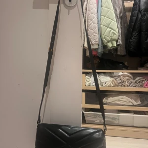 Axelremsväska - Svart axelremsväska från Hn