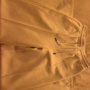 Vita kostymbyxor från H&M - Helt oanvända kostymbyxor i tricot från H&M i storlek XS. Breda byxben och knyt i midjan. 