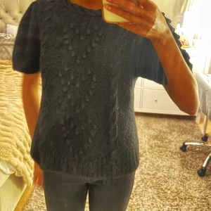 & Other Stories  kabelstickad kortärmad tröja - Säljer denna riktigt snygga svarta kabelstickade toppen med korta ärmar från &otherstories. Jättemjukt plagg och passar perfekt nu till hösten. Storlek L, men jag har vanligtvis S och den passar fint. Använd gärna ”köp nu”!