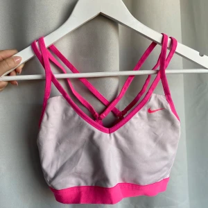 Sport-bh - Vit och rosa sport-bh från Nike. Fint skick. Storlek S. Inläggen är uttagna.