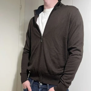 Brun helzip - Snygg brun kofta med dragkedja framtill. Perfekt för lager-på-lager och har en stilren design. Långärmad med ribbade muddar vid ärmslut och nederkant.