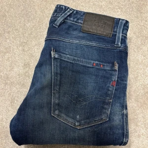 Replay Anbasss 31 W 32 L mörkblå - Snygga mörkblå jeans från Replay med en klassisk femficksdesign och lätt slitna detaljer. Riktigt bra skick, använda max 3 gånger