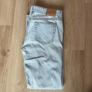 Ljusblå low waist jeans  - Säljer ett par ljusblå low waist jeans från weekday i modellen arrow. De har en klassisk straight fit och är tillverkade i denim. Perfekta för en avslappnad stil.