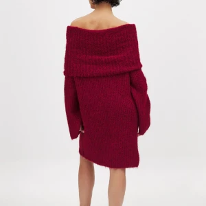 Vinröd stickad offshoulder klänning - Mysig vinröd stickad klänning med offshoulder-design och långa ärmar. Perfekt för kyligare dagar med sin varma och bekväma passform. Helt oanvänd med prislappen på. Från NAKD 