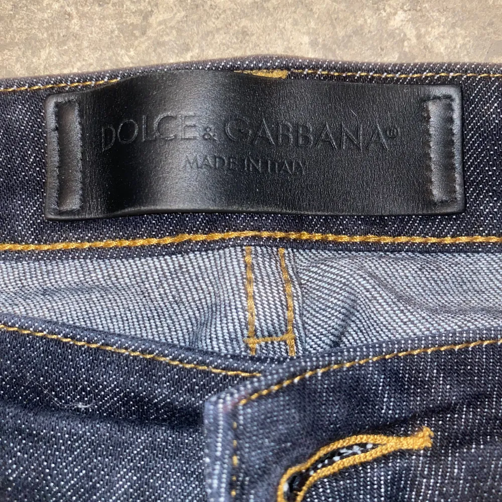 Snygga mörkblå jeans från Dolce & Gabbana med klassisk design. Tillverkade i Italien med en stilren läderdetalj på baksidan. Perfekta för en stilren look.. Farkut & Housut.