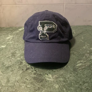 Polo Ralph Lauren X Wimbledon keps - Hej! Säljer denna feta kepsen från Polo med ett Wimbledon tema! Den har En stilren P-detalj på framsidan och polologgan på baksidan. Nypris är 1000kr. Funderingar om detaljer eller pris kan alltid begäras. För priset är som alltid diskutabelt. Ses! 😁